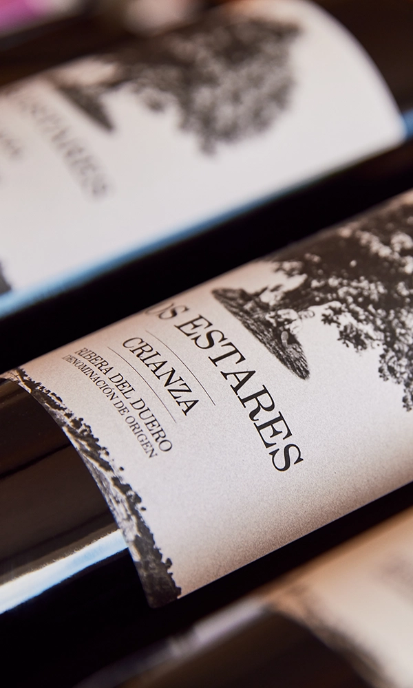 Primer plano de Botella de Crianza de la Bodega Pago de los Estares en Ribera de Duero tumbada junto a otras botellas